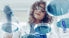Wissenschaftlerin im Labor arbeitet mit Petrischalen und einer Pipette.